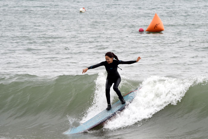 A participant in the International Surfing Contest enjoys surfing at Haeundae Beach in  Busan on June 28.