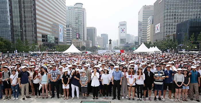 After attending a 70th anniversary ceremony at the Sejong Center for the Performing Arts, President Park Geun-hye (middle) and others create a giant Taegeukgi, the national flag, by wearing different colored caps, at Gwanghwamun Plaza in central Seoul on Aug. 15. 