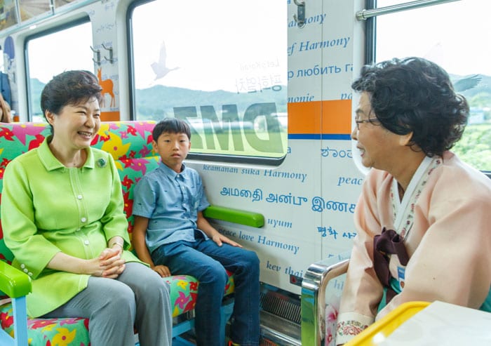 President Park Geun-hye (left) chats with passengers onboard the Gyeongwon Line on Aug. 5.