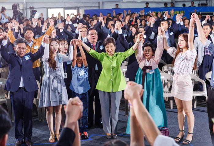 President Park Geun-hye (center) and other participants in the ceremony hold each other's hands and call out together, showing their will to realize a peaceful unification on the Korean Peninsula.
