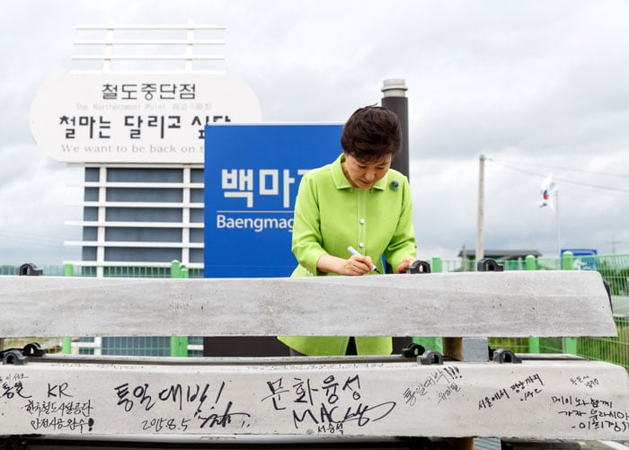 President Park Geun-hye signs one of the railway ties at Baengmagoji Station in Cheorwon-gun County, Gangwon-do Province, on Aug. 5.