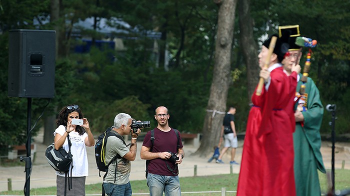 Tourists take pictures during the royal ancestral rituals in front of the Yeongnyeongjeon Hall at Jongmyo Shrine in Seoul over the recent Chuseok holiday.