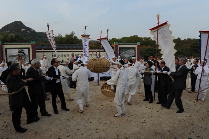 A traditional ceremony where people harden the earth before construction, a <i>jigyeong dajigi</i>, takes place during a ceremony that marks the beginning of restoration work at the Heungbokjeon, at Gyeongbokgung Palace on Oct. 23.
