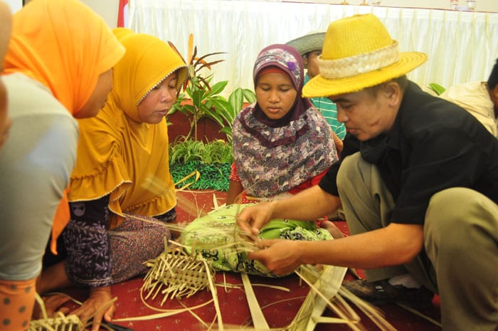 Participants in an ecotourism educational program learn how to make ecofriendly handicrafts.