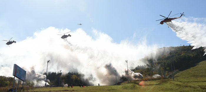 Helicopters put out a forest fire during a joint fire fighting drill on Oct. 14 in Pyeongchang.