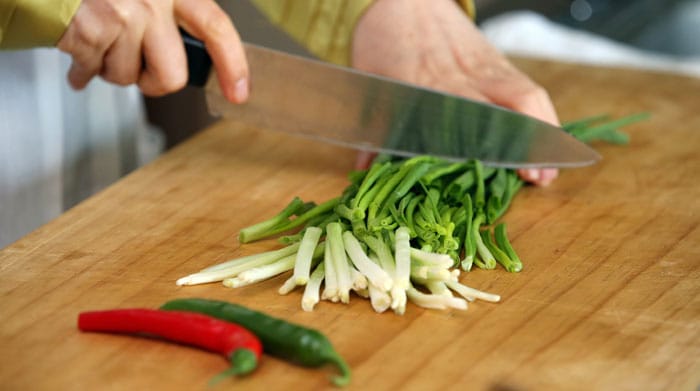 Cut the green and red pepper into diagonal 2 centimeter slices. Trim and wash the small green onion and cut it into 10 centimeter strips.