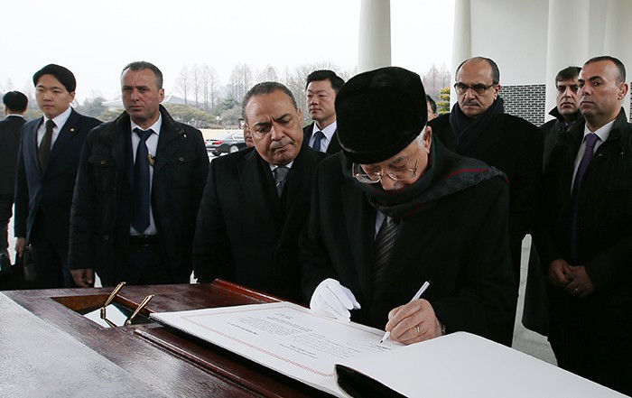 Palestinian President Mahmoud Abbas signs the guestbook after paying his respects at the Seoul National Cemetery on Feb. 18 in Seoul.