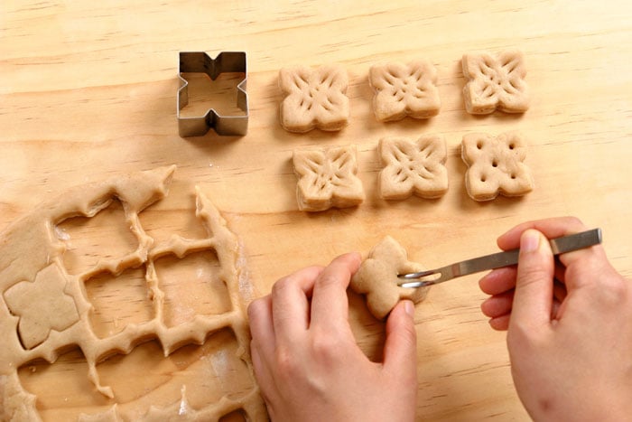 Roll the dough flat and use a cookie cutter to make <i>yakgwa</i>-shaped cookies. Poke 5 or 6 holes in them with a chopstick.