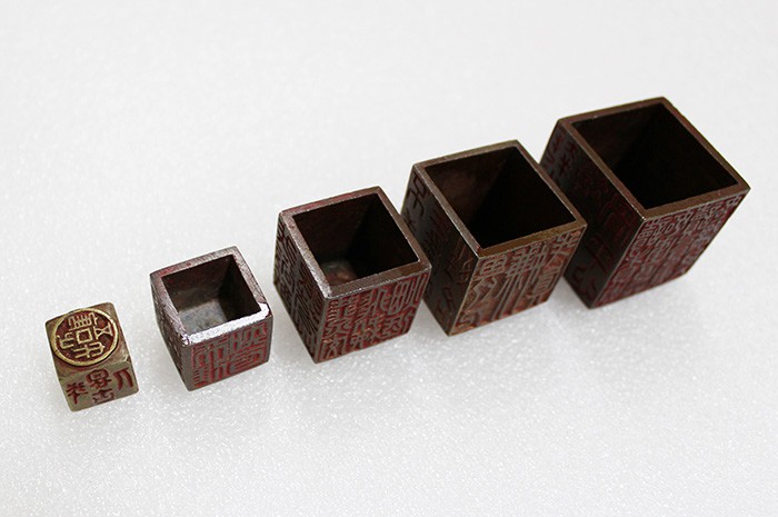 The four boxes that held the royal seal of Heungseon Daewongun, plus the seal itself, are collectively known as the <i>ogae sabibin</i> (오개삽입인, 五個揷入印). They're intricately formed so that they cover and keep each of the smaller boxes, according to size. Each side of the boxes is carved with words and phrases.