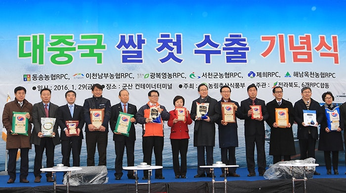 Korean government representatives, including Minister of Agriculture, Food and Rural Affairs Lee Dong-Phil, heads of local governments from Jeollabuk-do Province, and rice exporters pose for a photo while holding packets of rice during a celebration to mark the first export of Korea rice to China. The celebration took place at Gunsan Port on Jan. 29.