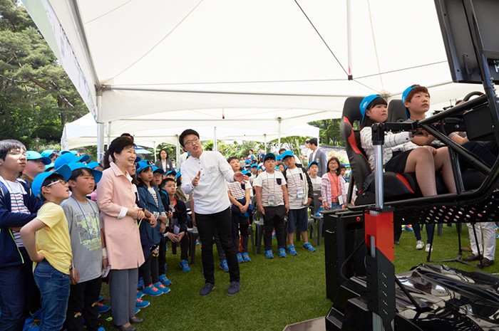 President Park Geun-hye watches children race cars in a so-called '4-D video game' during a special event to mark Children’s Day at Cheong Wa Dae on May 5.