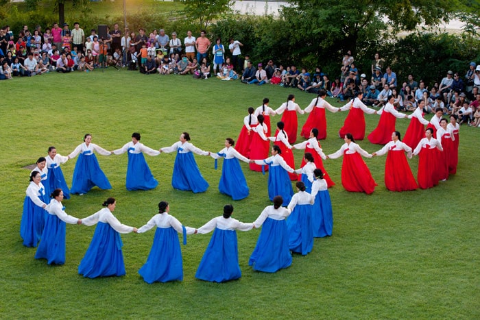 Visitors to the National Folk Museum of Korea enjoy a <i>ganggangsullae</i> performance. <i>Ganggangsullae</i> is a circle dance involving singing and folk games. It used to be performed by women at night under the full moon on the day of Chuseok.