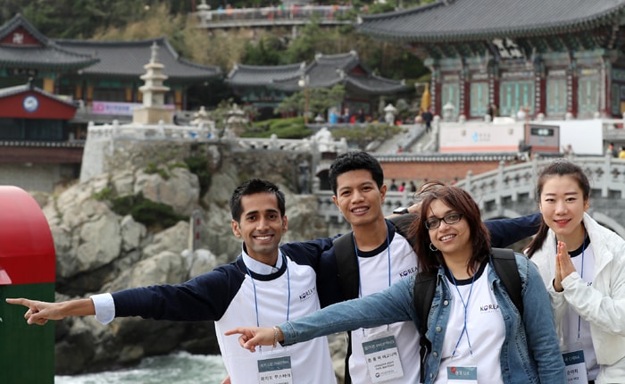 Korea.net honorary reporters pose against the backdrop of Haedong Yonggungsa Temple situated atop the ocean waves, in Busan on Oct. 27.