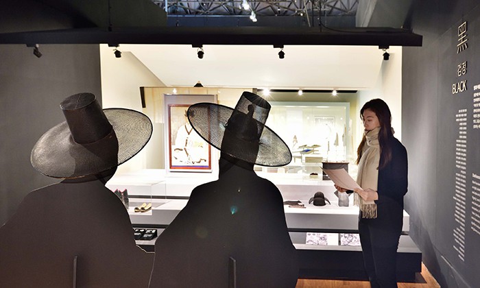 Black is connected to white. It is also the color of death, darkness and authority. In the photo, a museum-goer appreciates displays in the black section of the exhibition.