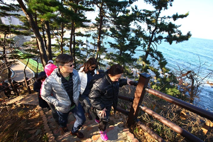 A group of Singaporean tourists appreciate the scenic views off into the East Sea on Nov. 29 as they walk along the Haeparang Trail, the country's longest series of walking trails. They're participating in a group tour that follows in the footsteps of Singaporean Prime Minister Lee Hsien Loong.