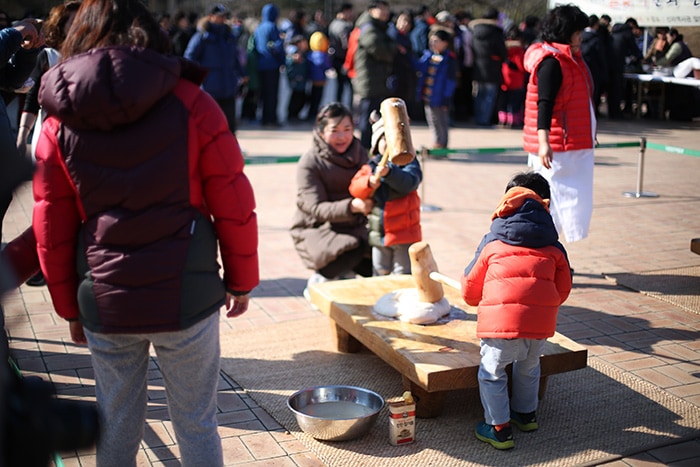 Visitors to the Gyeongju National Museum beat rice dough with a wooden mallet, one of the traditional practices of the Seollal Lunar New Year's holidays.