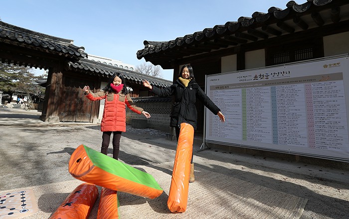 28일 운현궁을 찾은 자매가 대형 윷을 던지며 설날을 대표하는 전통놀이인 ‘윷놀이’를 하고 있다.