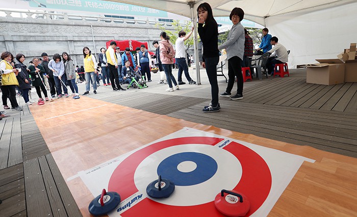 Visitors to the 31st drawing competition for the disabled try their hand at curling at the National Folk Museum of Korea where a hands-on events were held to promote the PyeongChang 2018 Olympic and Paralympic Winter Games, in Seoul on April 25.