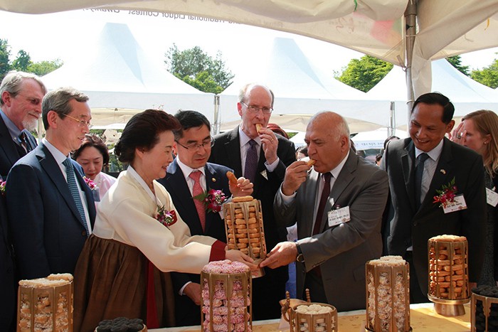 Korean Food Foundation President Yoon Sook-ja offers a <i>jungbakgye</i>, a traditional cookie prepared for royal ceremonies, to Turkish Ambassador to Korea Arslan Hakan Okcal, at the Namsagol Hanok Village in Seoul where the 10th Korean Traditional Liquor & Food Festival took place on May 18.