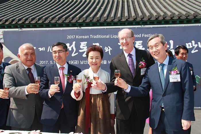 Turkish Ambassador to Korea Arslan Hakan Okçal (left), Edwin C. Sagurton (fourth from left), the minister-counselor for political affairs at the U.S. Embassy in Korea, and other dignitaries attend the opening ceremony of the 10th Korean Traditional Liquor & Food Festival, at the Namsagol Hanok Village in Seoul on May 18. Each diplomat holds a glass of <i>ogamju</i>, a type of traditional Korean liquor made from five medicinal ingredients.