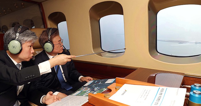 President Moon Jae-in (right) looks around the Saemangeum, an area of reclaimed land in Jeollabuk-do Province, along with Lee Byoung-gook, administrator of the Saemangeum Development and Investment Agency, while flying over the Yellow Sea in a helicopter on May 31.