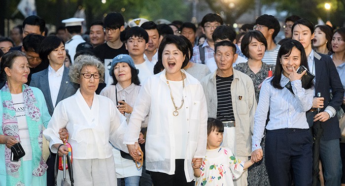 First lady Kim Jung-sook (center) and a crowd on June 26 walk along the pedestrian road in front of Cheong Wa Dae.