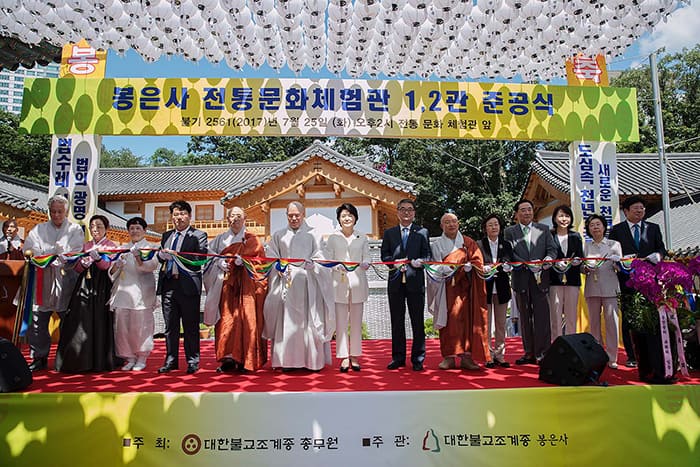 First lady Kim Jung-sook (center) helps to cut the ribbon during a ceremony to mark the establishment of a 'traditional culture experience hall' at Bongeunsa Temple in Gangnam-gu district, Seoul, on July 25.