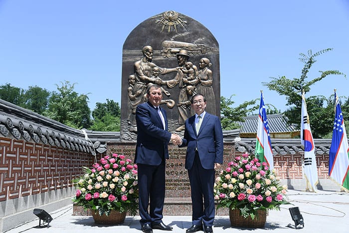 Tashkent Mayor Rakhmonbek Usmanov (left) and Seoul Mayor Park Won Soon shake hands at the unveiling of a monument to commemorate the 80th anniversary of the deportation of ethnic Koreans to Uzbekistan, at Seoul Park in Tashkent on July 3. (Seoul Metropolitan Government)