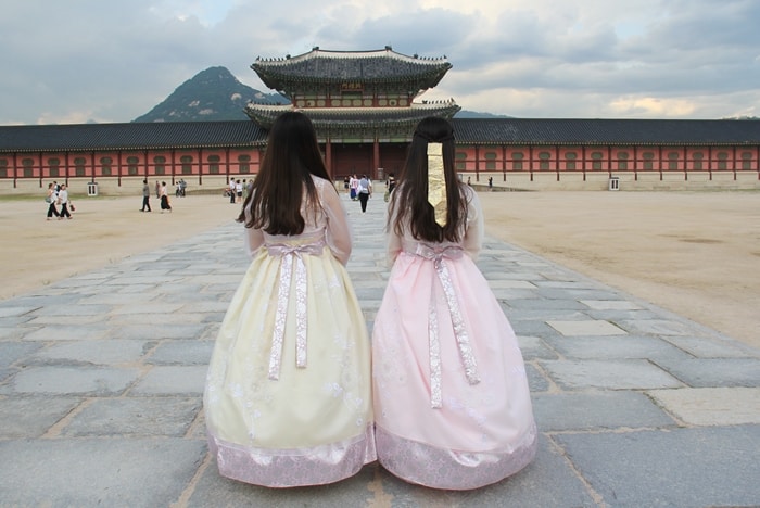 Tourists stroll through Gyeongbokgung Palace wearing modernized Hanbok rented from a local Hanbok shop on Aug. 11.