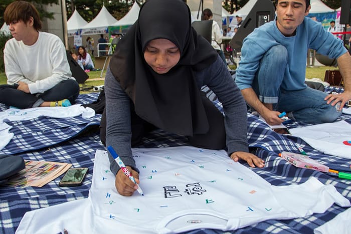 Malaysian competitor Zahra Zahan writes Korean consonants and vowels on a T-shirt, as part of a Hangeul T-shirt design competition at the National Hangeul Museum on Oct. 8, one day before the 571st anniversary of the creation of the Korean alphabet.