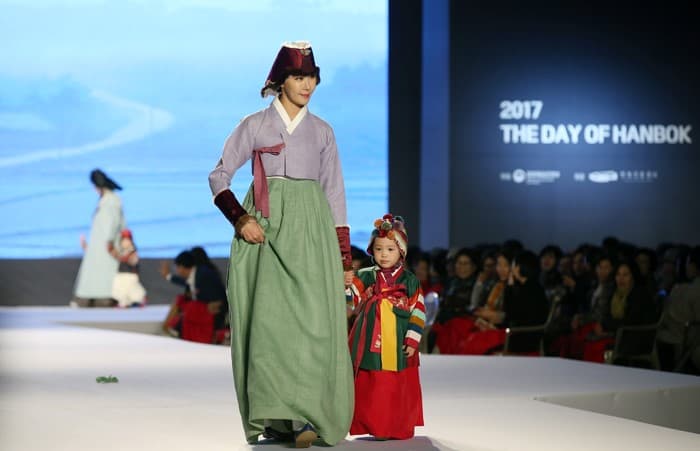 One day ahead of Hanbok Day, an adult and a child modeling Hanbok showcase the elegance of their attire, during the Moonlight Hanbok Fashion Show at the Heungnyemun Gate of Gyeongbokgung Palace, in Seoul on Oct. 20.