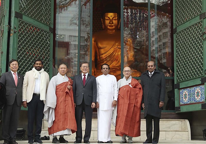 President Moon Jae-in (center) poses for photos with Sri Lankan President Maithripala Sirisena on Nov. 28 at Jogyesa Temple in Seoul.