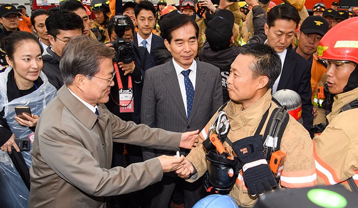 President Moon Jae-in (left) delivers words of encouragement to firefighters on the 55th anniversary of Firefighters Day at the Fire Service Academy in Cheonan, Chuncheongnam-do Province, on Nov. 3.
