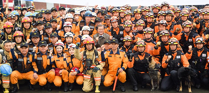 President Moon Jae-in poses for a photo with firefighters on the 55th anniversary of Firefighters Day at the Fire Service Academy in Cheonan, Chuncheongnam-do Province, on Nov. 3.
