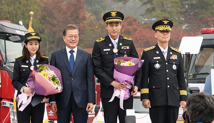 President Moon Jae-in (second from left) poses for a photo with actress Han Ji-min (left) and actor Jung Woo-sung (third from left) after appointing them as honorary firefighters, on the 55th anniversary of Firefighters Day at the Fire Service Academy in Cheonan, Chuncheongnam-do Province, on Nov. 3.