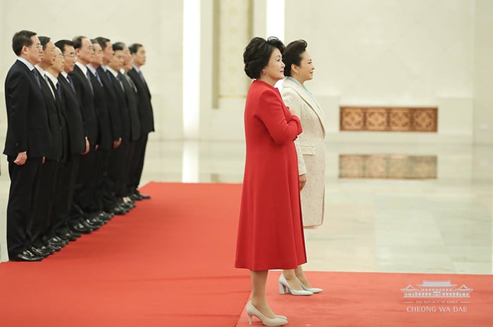 First lady Kim Jung-sook (center, in red) and Chinese first lady Peng Liyuan attend an official welcoming ceremony at the Great Hall of the People, in Beijing on Dec. 14. The two first ladies visited the National Centre for the Performing Arts later that day.