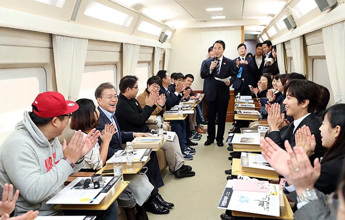 President Moon Jae-in talks with winners of the PyeongChang Idea Olympics onboard the presidential train heading to Gangneung, Gangwon-do Province, on Dec. 19. (Cheong Wa Dae)