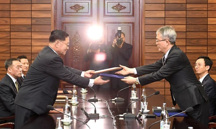 Director Kwon Hyok Bong (left) of North Korea’s Performing Arts Bureau, part of the North Korean culture ministry, and Deputy Minister for Culture and Art Policy Lee Woosung from the Ministry of Culture, Sports and Tourism, exchange a joint press release after working level talks at the Tongilgak building in the Panmunjom truce village on Jan. 15. (Ministry of Unification)