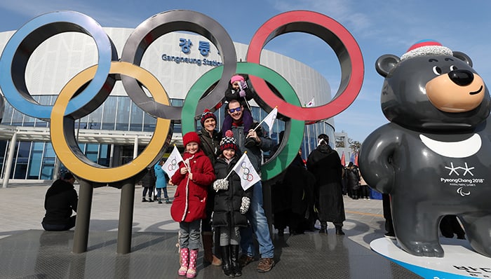 Berky Bruso (second from left) and her family pose for a photo at the Olympic symbol and Bandabi, the mascot for 2018 Paralympic Winter Games, in front of Gangneung Station on Feb. 15. Bruso said her family enjoyed watching the cultural events here and that they would love to have more opportunities to learn about Korean heritage and traditions. Her youngest daughter is wearing a Soohorang backpack.