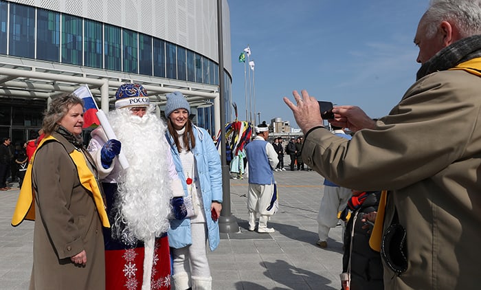 The square in front of Gangneung Station has become the latest spot to make an Olympic memory for many tourists. Volunteer worker Sister Nilson (left) poses for a photo with Des Moroz from Russia wearing a Father Winter costume, in front of the station on Feb. 15.