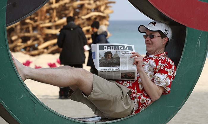Scott Cunningham from Dallas, Texas, poses for a unique photo while pretending to read the Roll Call while wearing a Hawaiian shirt and shorts, at Gyeongpo Beach on Feb. 22.