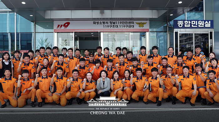 First lady Kim Jung-sook (center) poses for a photo with firefighters at a fire station in Hwaseong, Gyeonggi Province, on Aug. 8.