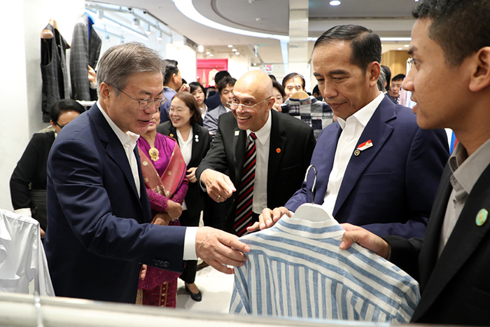 President Moon Jae-in (left) and Indonesian President Joko Widodo select a shirt while shopping at the Dongdaemun Design Plaza, in Seoul on Sept. 10.