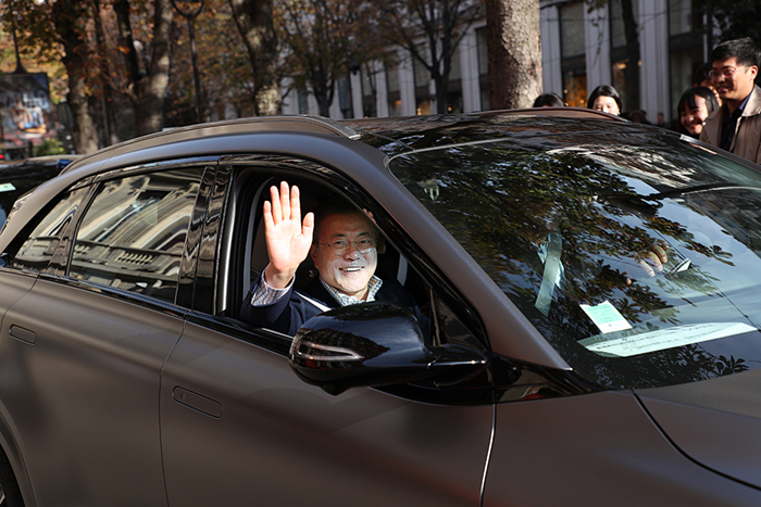 President Moon Jae-in, on his state visit to France, waves his hand while test riding Hyundai’s hydrogen fuel-cell car Nexo in Paris on Oct. 14.