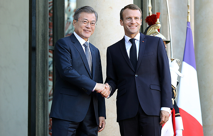 President Moon Jae-in (left) and French President Emmanuel Macron shake hands after arriving at Élysée Palace in Paris on Oct. 15.