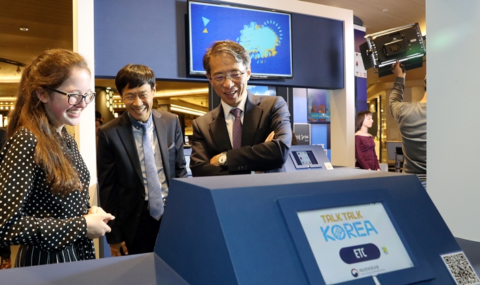 Director Kim Tae-hoon of the Korean Culture and Information Service (right) listens to an explanation about the winning work of Piper Bo, a 15-year-old from the United States who won the top prize in the category of Korean music and drama at the exhibition of the Global Talk Talk Korea Contest 2018 on Oct. 16. The exhibition opened on Oct. 16 at the Parnas Mall of Grand Intercontinental Seoul in Gangnam-gu District, Seoul.
