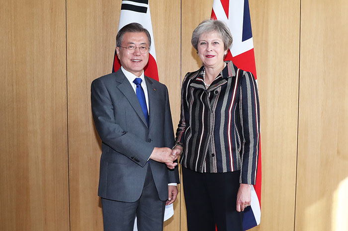 President Moon Jae-in (left) poses for photos with U.K. Prime Minister Theresa May prior to their summit on Oct. 19 on the sidelines of the 12th summit of the Asia-Europe Meeting (ASEM) in Brussels, Belgium. (Cheong Wa Dae)