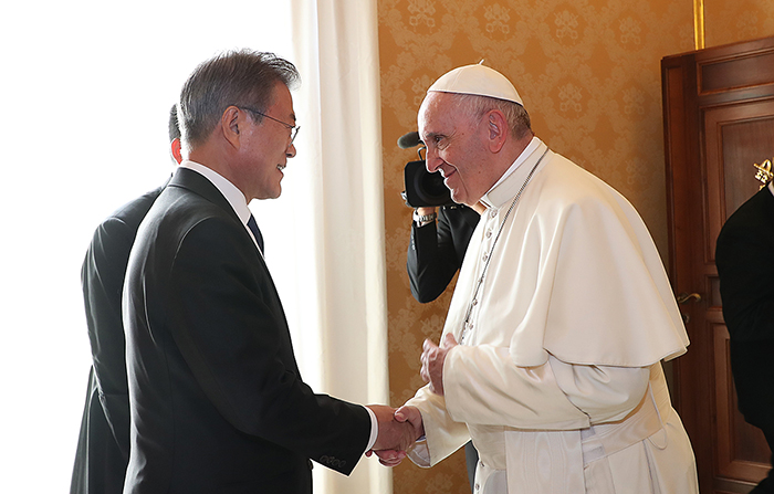 President Moon Jae-in (left) shakes hands with Pope Francis, during his official visit to the Vatican on Oct. 18.