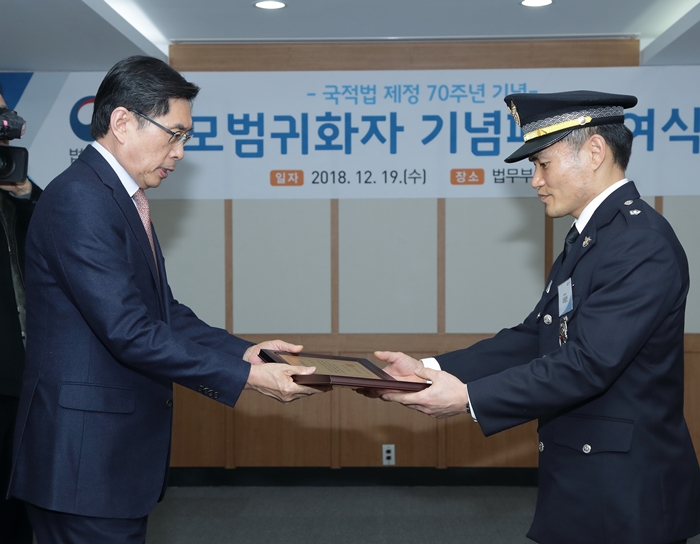 Justice Minister Park Sang-ki (left) on Dec. 19 awards a plaque to Lee Dong-bin, one of four naturalized Koreans recognized as exemplary citizens, at a ceremony marking the 70th anniversary of the Nationality Act at the Government Complex-Gwacheon in Gwacheon, Gyeonggi-do Province.