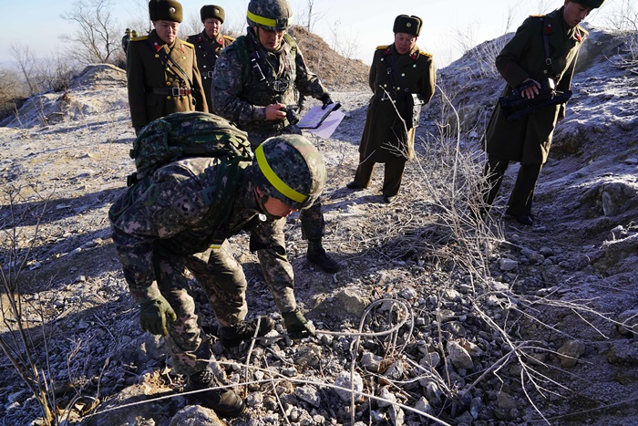 South Korean inspectors on Dec. 12 examine the ruins of a North Korean guard post inside the Demilitarized Zone.